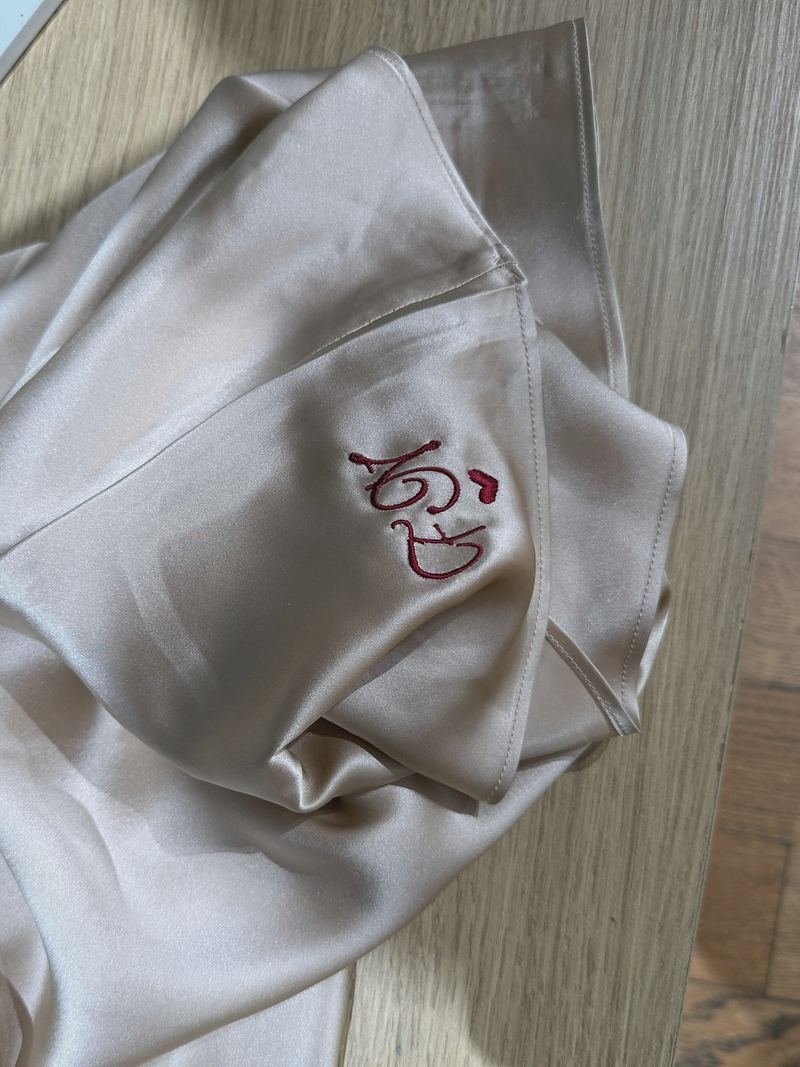 Monogramme brodé en fil rouge sur une nuisette en satin champagne