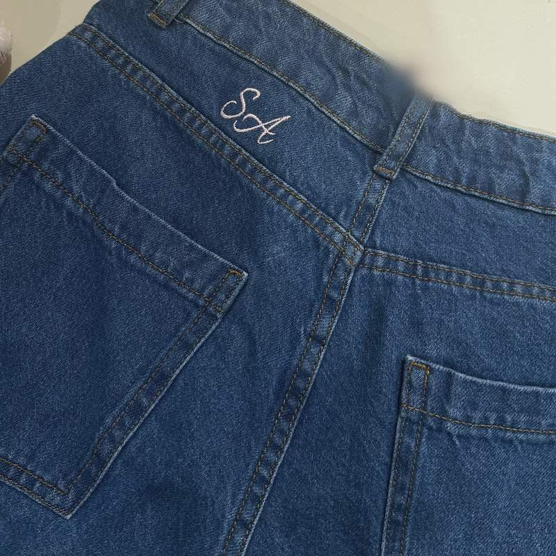 Initiales SA brodées sur la poche arrière d'un jean