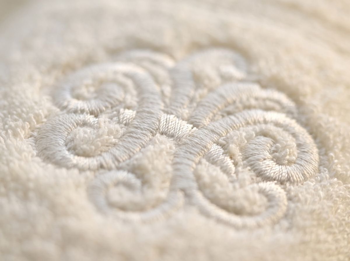 Détail d'un monogramme brodé ton sur ton sur une éponge